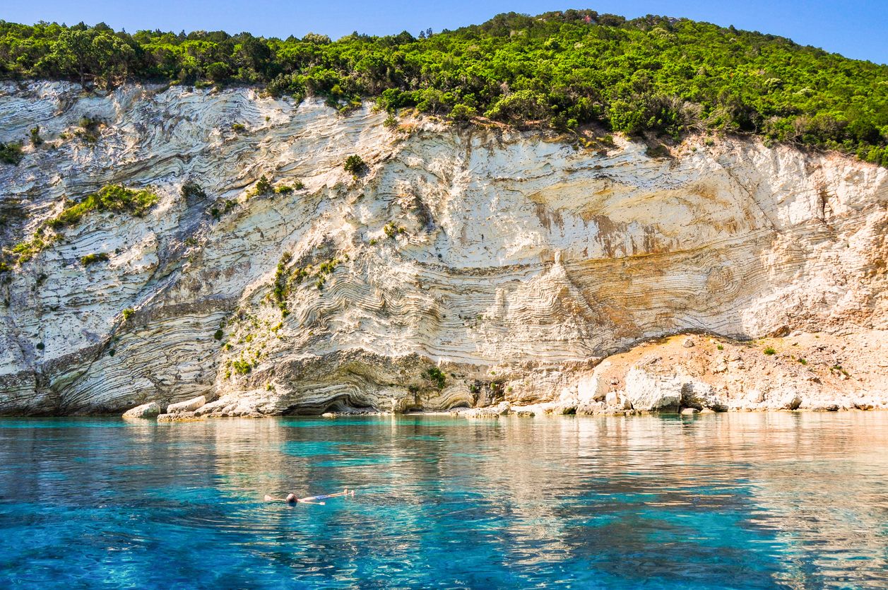 Mies uimassa lahdella Atokos-saarella, Kreikassa