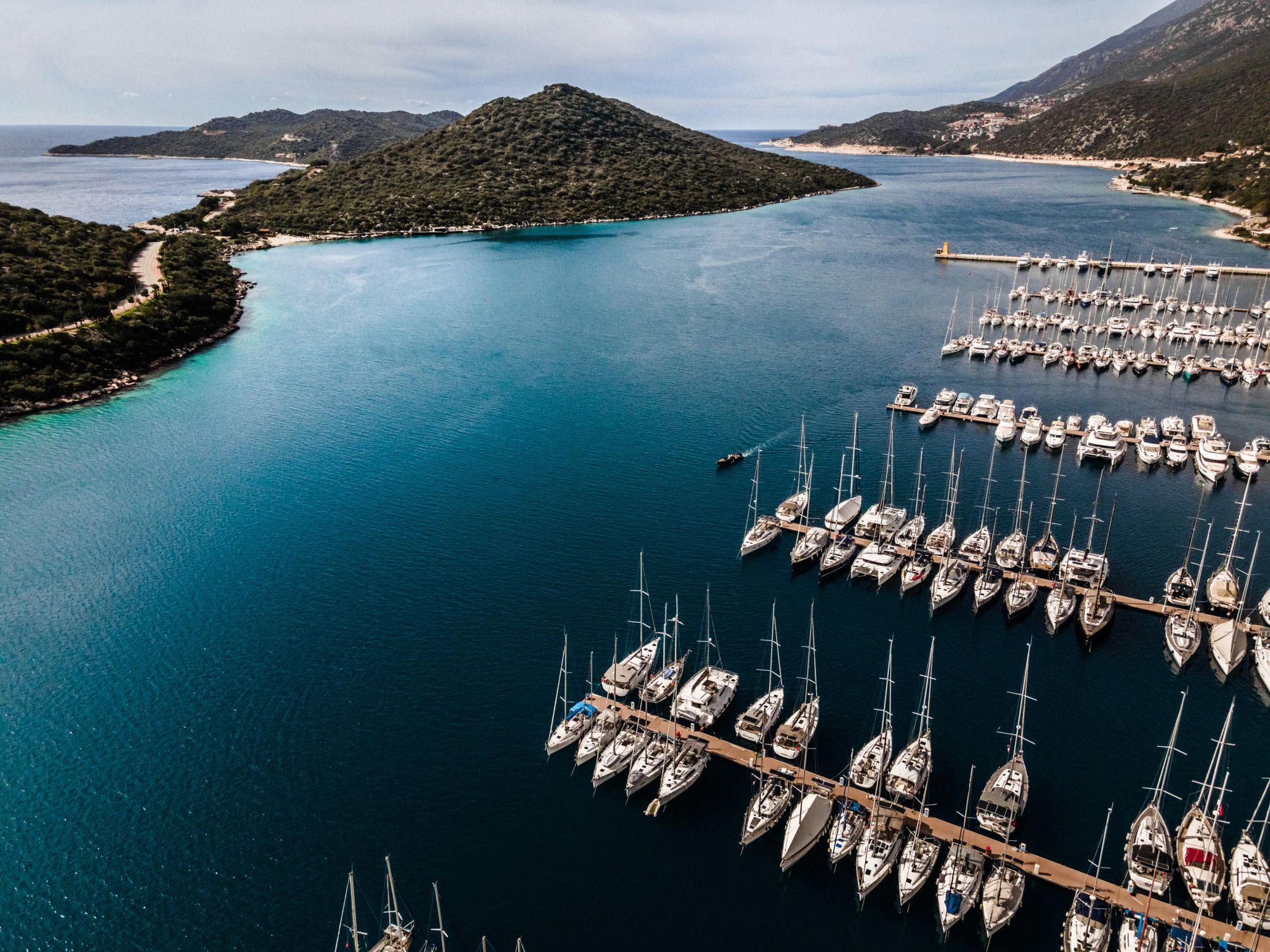 Letecký pohľad z dronu na prístavný záliv, more a hory na pozadí. Kaş, Turecko