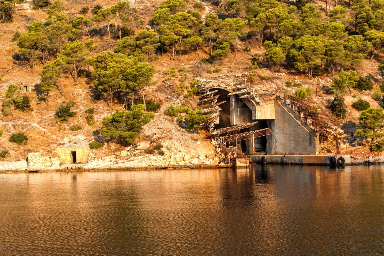 Submarine and ship bunker on Brac island, Croatia. Concrete bunker shelter for submarines in adriatic sea. Travel on a yacht in Croatia. Morning in the Bay of Smrka.