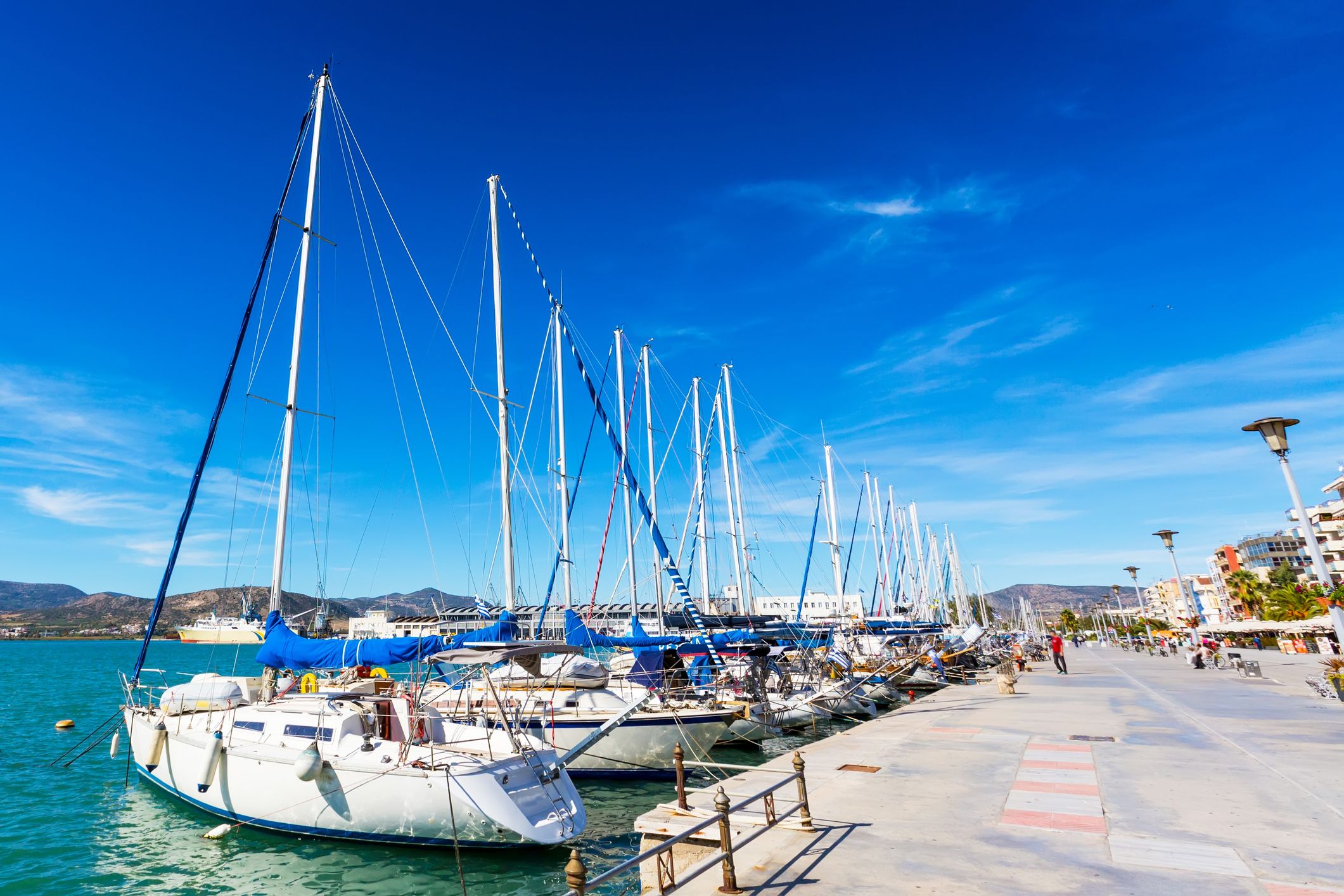 Sailing ships and yachts stand moored in the port of Volos, Greece