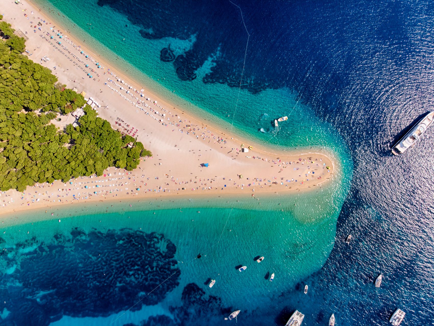 Letecký záber na pláž Zlatni Rat s loďami v Chorvátsku
