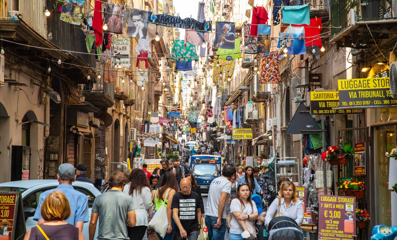 Via dei Tribunali central busy street in Napoli old town, people walking on the street.
