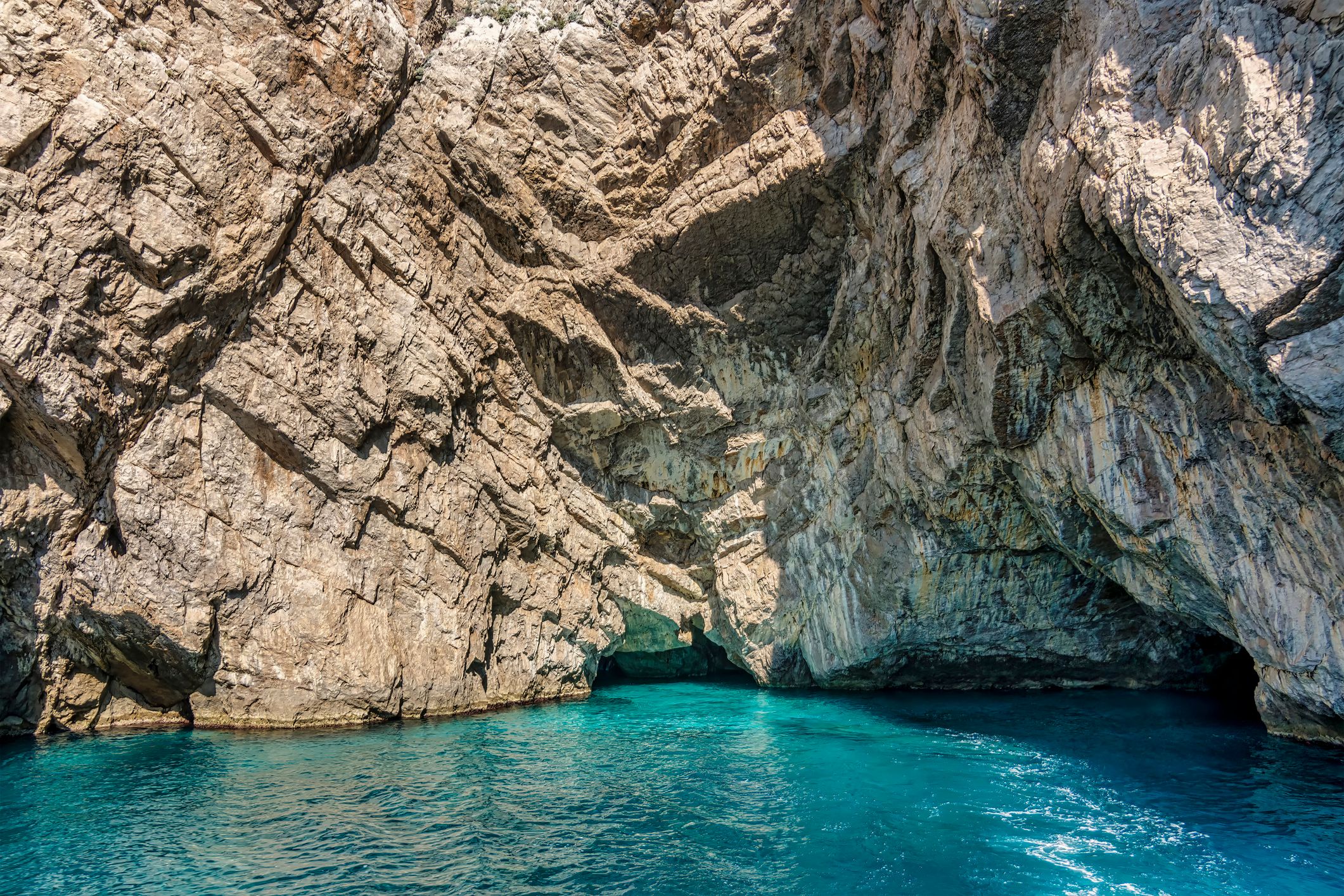 View from the boat of a Boat with tourists along the cliffs and rocky coast of Capri Island.