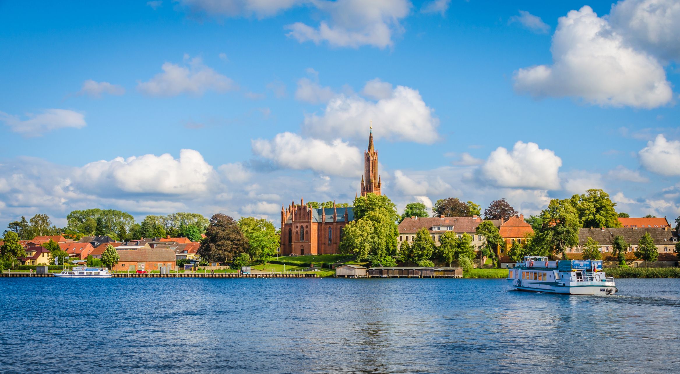 View of malchow monastery with an excursion boat on Lake Malchow in the Mecklenburg Lake District.