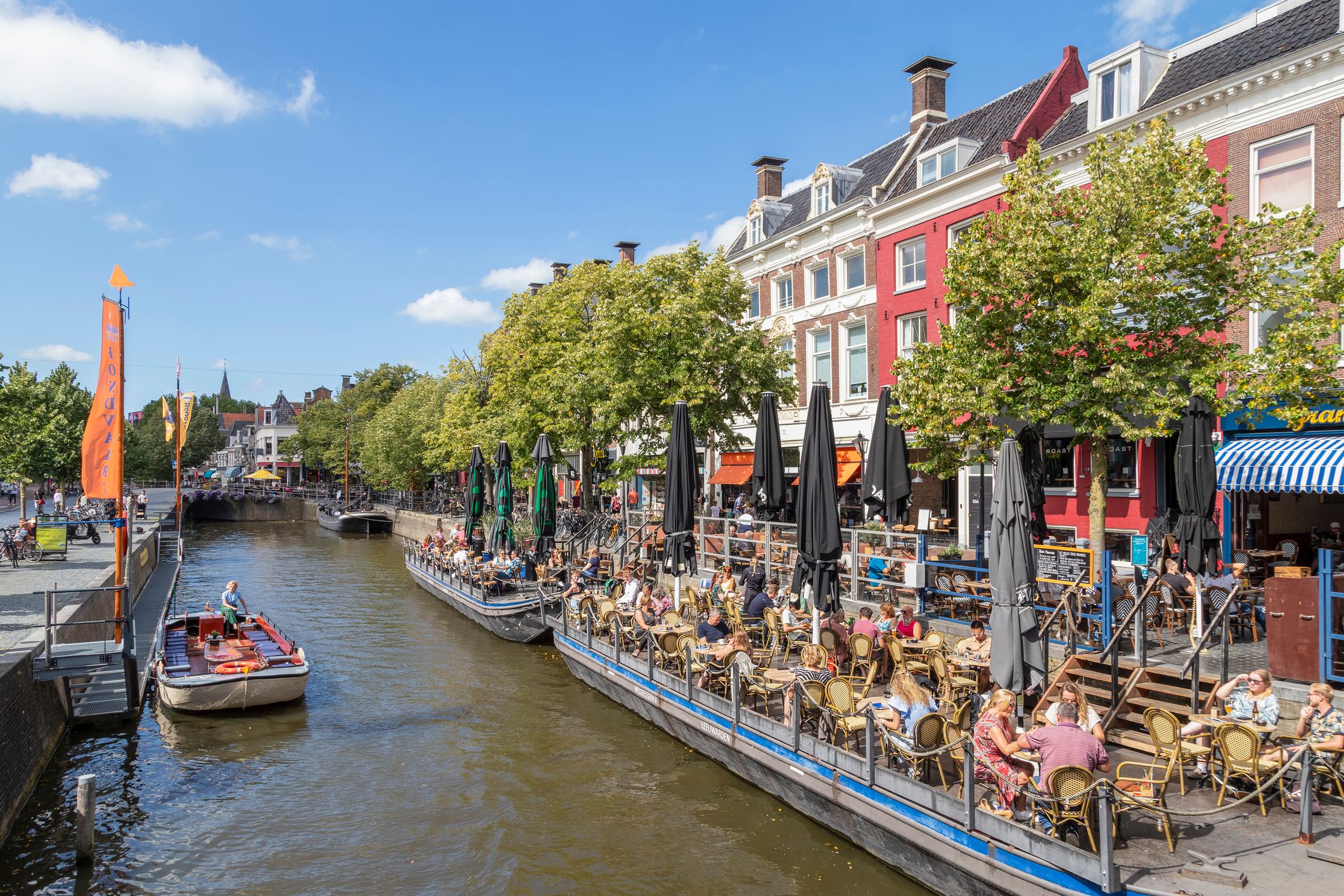 People enjoy the beautiful weather in Leeuwarden along the water.