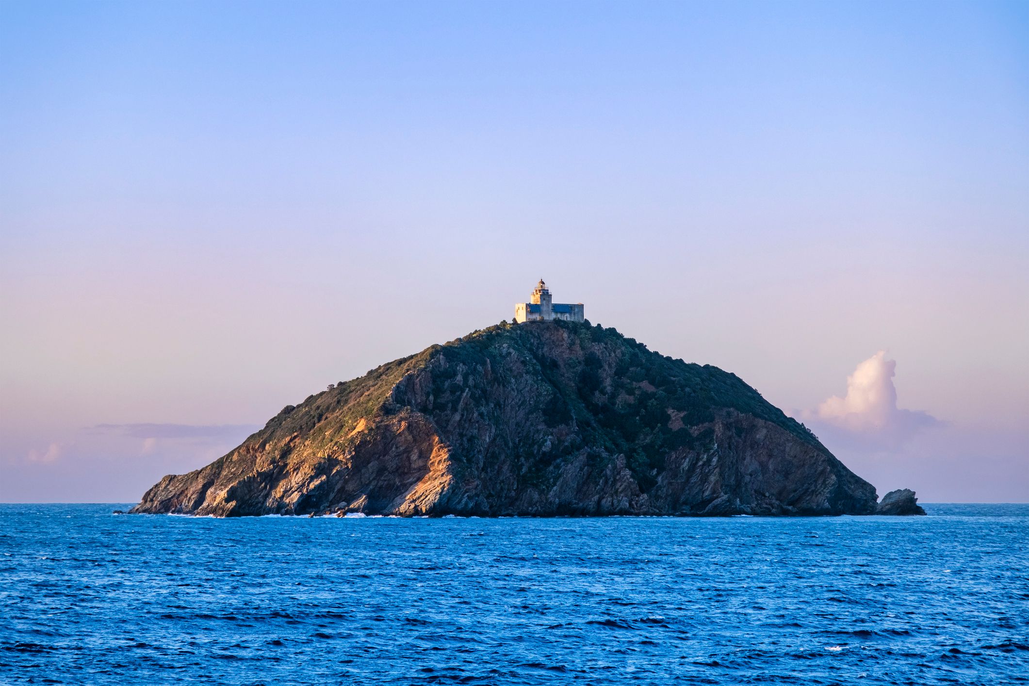 Palmaiola, islet of the Tuscan Archipelago, seen from the sea at sunset.