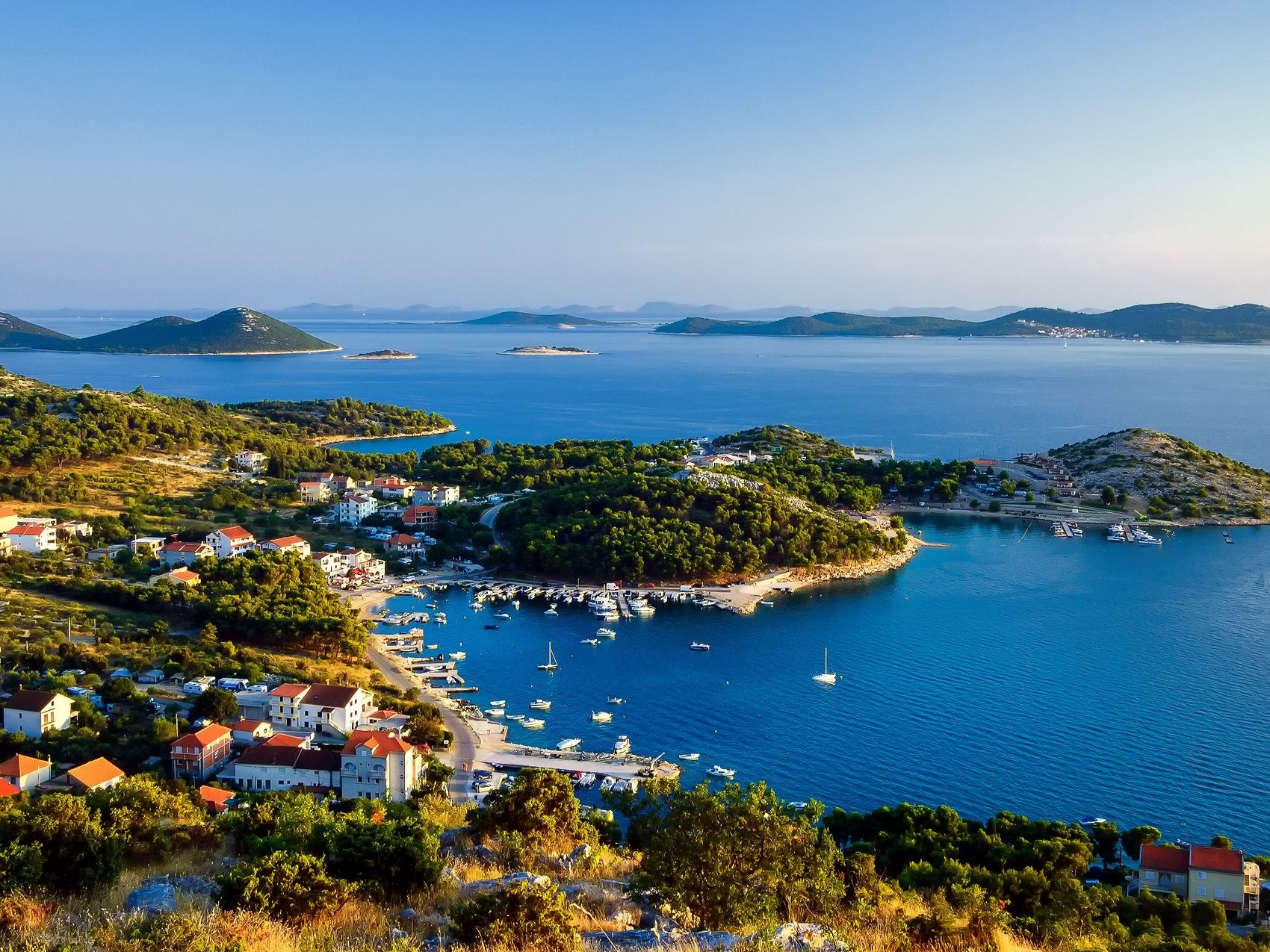 Croatian bay with blooming greenery with anchored boats