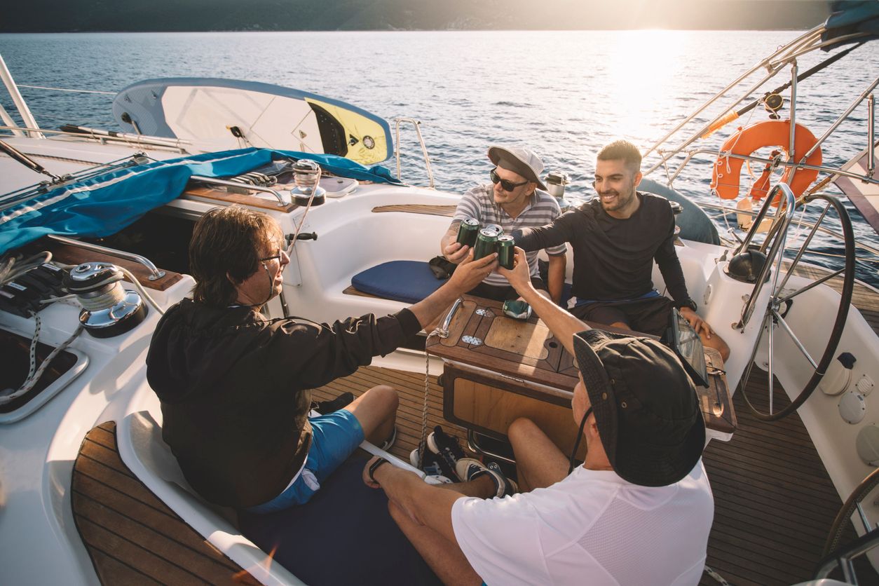 Group of friends enjoy sailing and cheering with beer.