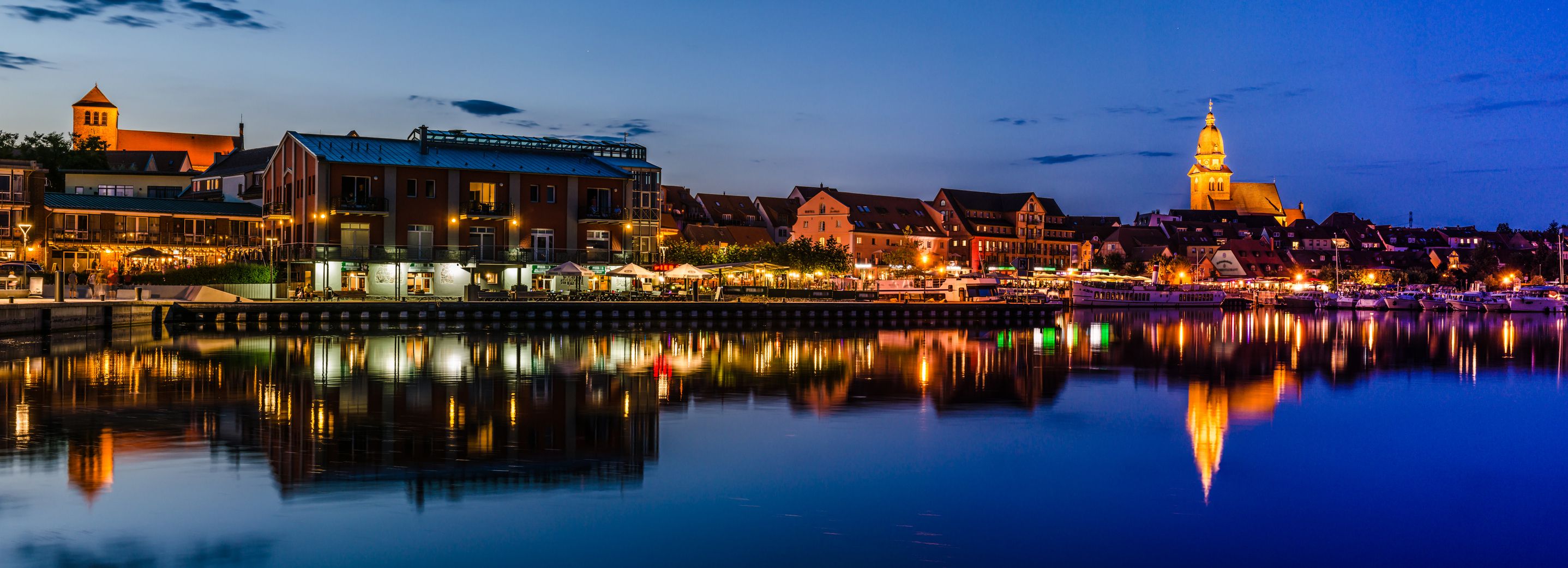 Panoramic picture of the harbour and the old town of Waren an der Müritz at the Blue Hour in the evening.