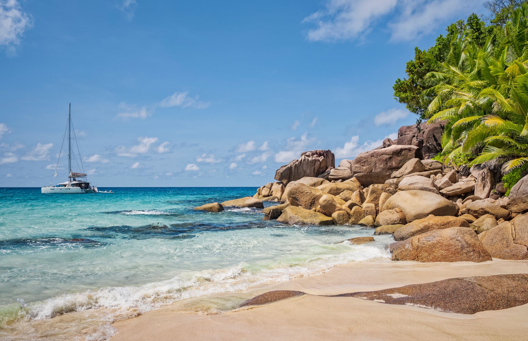 Tropical beach Anse Georgette with typical granite rock formations and palm trees on Praslin island